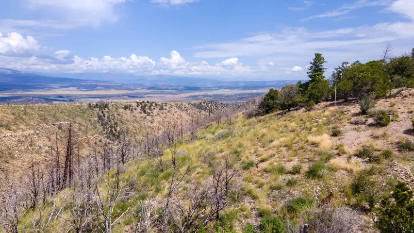 Expansive hillside property featuring distant mountain ranges and a vast valley