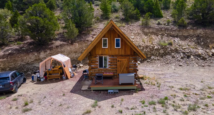 Rustic log cabin featuring an A-frame roofline and a front deck