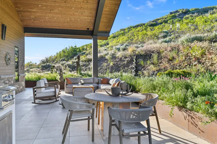Covered patio featuring a wood-paneled ceiling and stone accent wall