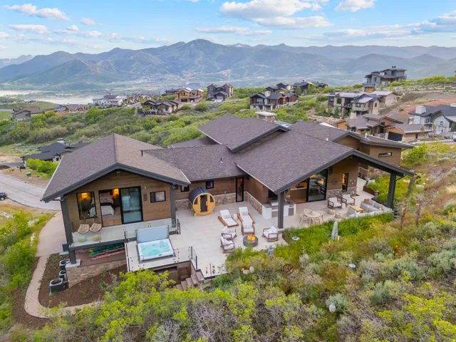 Contemporary mountain home featuring expansive multi-level outdoor living spaces, a covered patio, a hot tub, and a barrel sauna