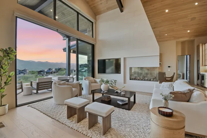 Vaulted ceiling with wood-finish planks, expansive sliding glass doors, contemporary linear fireplace, light wood-finish flooring, and recessed lighting