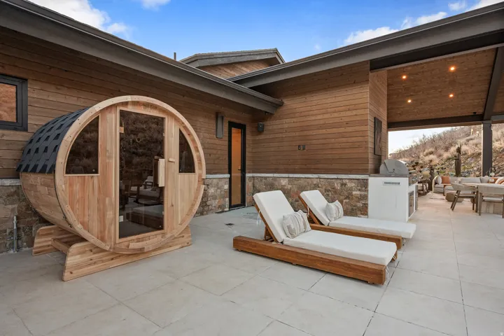 Outdoor barrel sauna on a stone patio