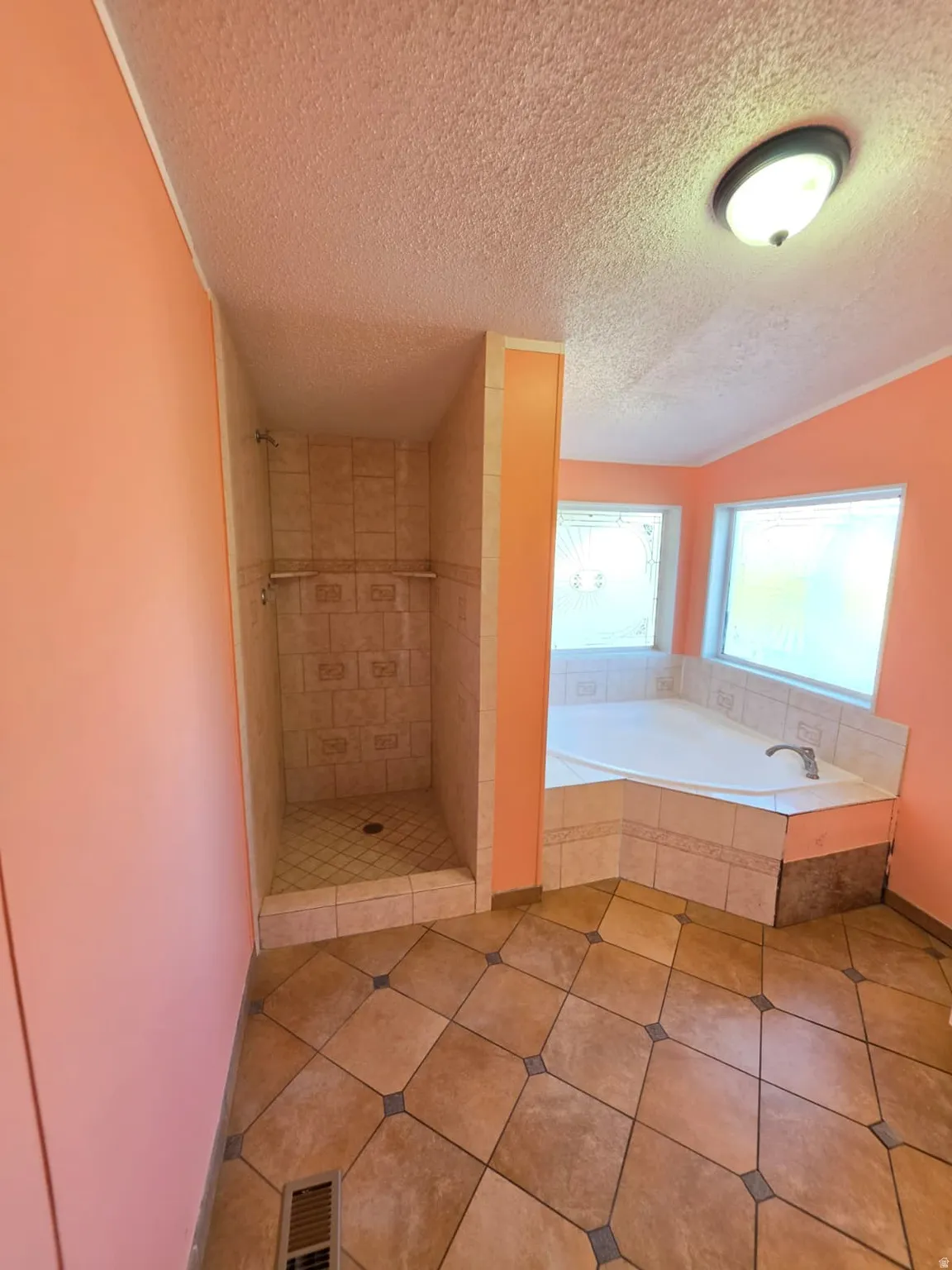 Bathroom featuring a corner soaking tub, a tiled shower enclosure, ceramic tile flooring, and a flush-mount ceiling light fixture