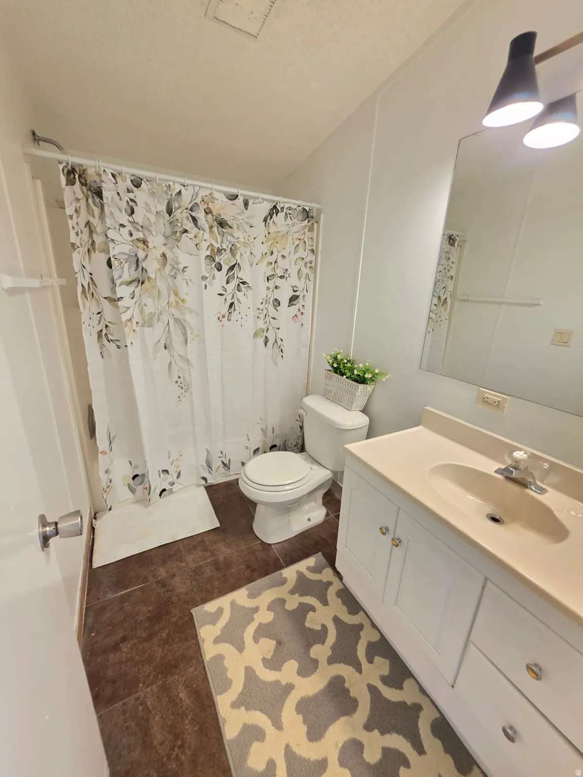 Bathroom featuring a white vanity with integrated sink, chrome faucet, and storage cabinetry