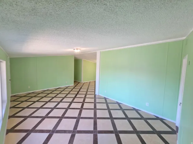 Spacious interior featuring patterned tile flooring, light green wall panels, and white trim