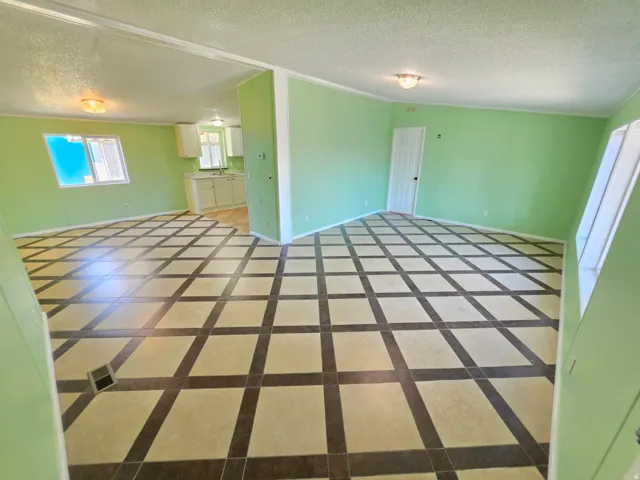 Spacious interior featuring patterned tile flooring, light green walls, and white trim