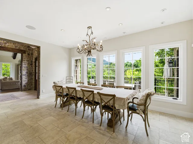 Spacious dining room featuring a decorative chandelier, recessed lighting, and large multi-pane windows