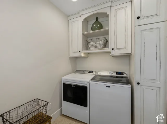 Laundry area featuring distressed white cabinetry with black hardware, built-in shelving, and a neutral wall color