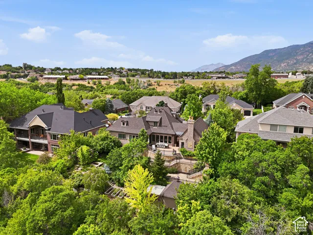 Expansive property featuring a multi-level home with a dark shingle roof and brick exterior