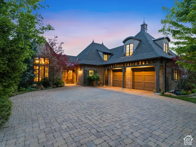Stone and brick exterior with a large paver driveway