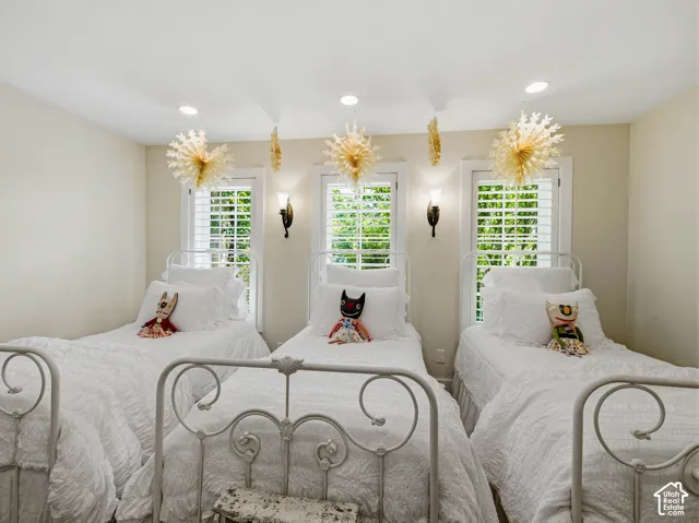 Room with three windows featuring plantation shutters and exterior tree views