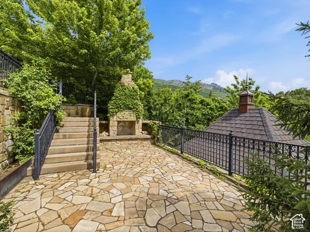 Flagstone patio with a built-in outdoor fireplace and stone retaining walls