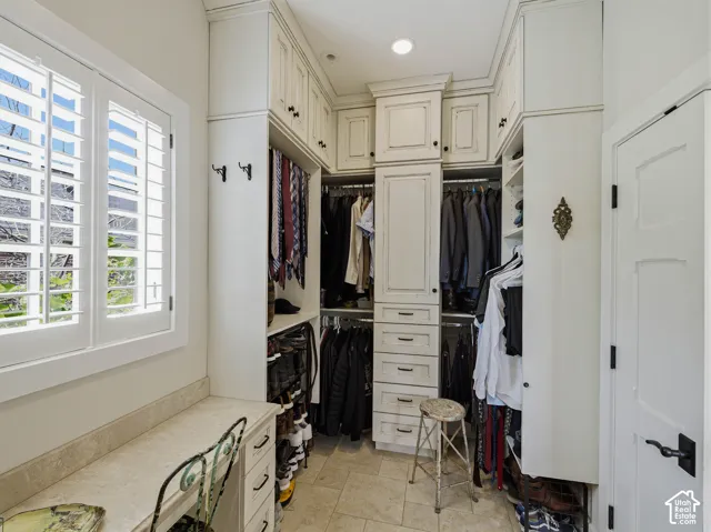 Custom closet system with built-in cabinetry, drawers, and hanging rods