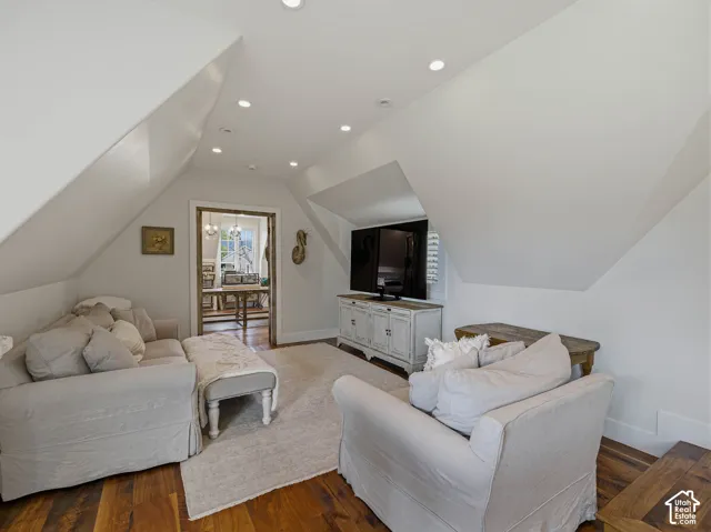 Attic living space featuring wood-finish flooring, recessed lighting, and a white media console