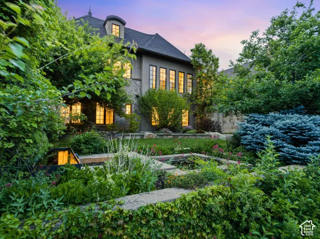 Landscaped terraced garden featuring lush plantings, a multi-level water feature, and stone retaining walls