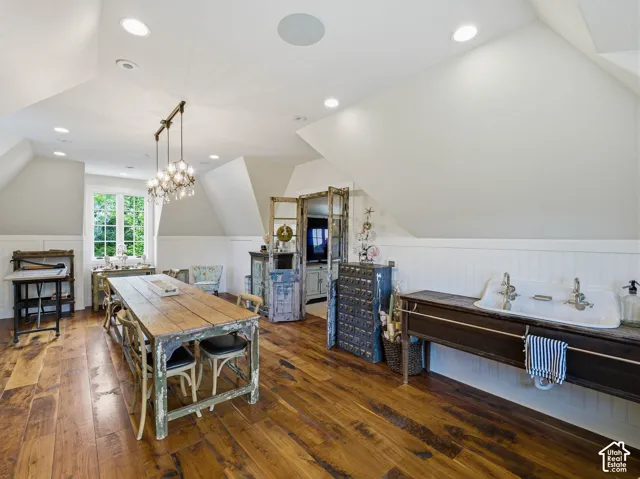 Spacious room featuring wood-finish flooring, white beadboard wainscoting, and recessed lighting