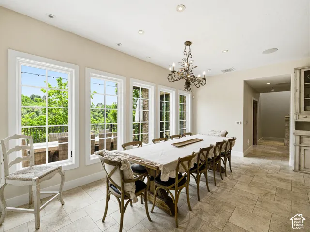 Dining area featuring multiple windows, recessed lighting, and a decorative chandelier