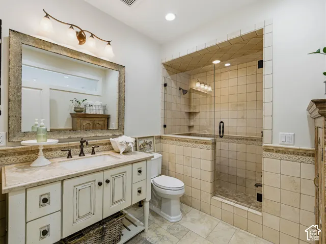 Bathroom featuring a distressed-finish single vanity with a solid surface countertop and undermount sink