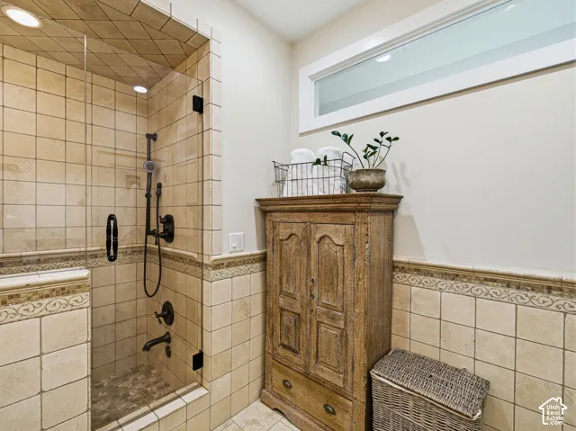 Glass-enclosed shower with a handheld showerhead and built-in niche