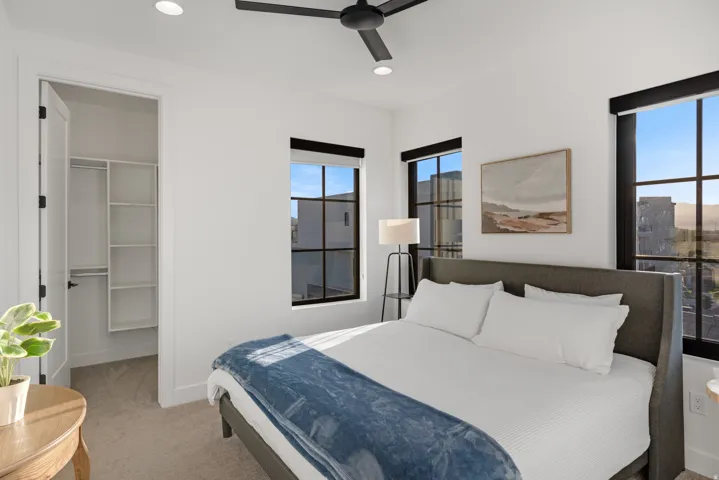 Bedroom featuring ample natural light from multiple windows, a ceiling fan, recessed lighting, and a closet with built-in shelving