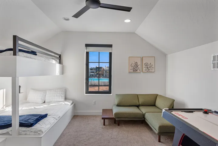 Spacious room featuring vaulted ceilings, a built-in bunk bed system, and a window with black grid panes