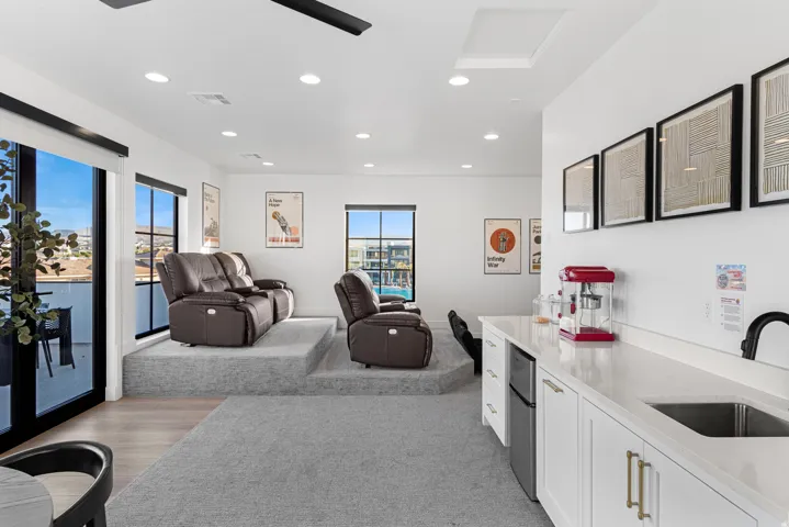 Entertainment area featuring tiered carpeted seating platforms and a built-in wet bar