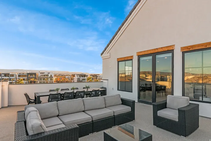 Rooftop patio with smooth stucco exterior, dark-framed windows, and a glass-paneled door