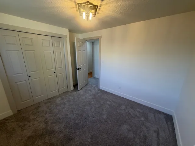 Bedroom 2. Bedroom featuring plush gray carpeting, white walls, and white baseboards