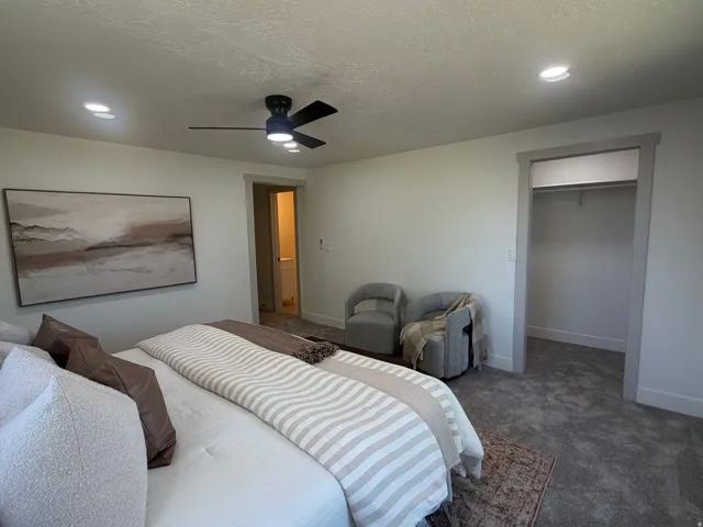 Master bedroom. Plush carpeting throughout with a contemporary ceiling fan and recessed lighting