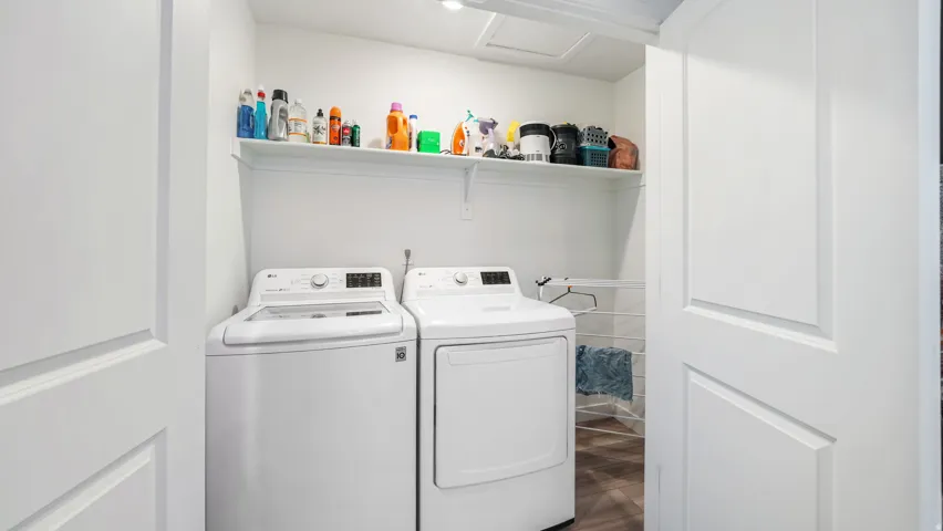 Dedicated laundry area featuring white appliances, a top-loading washing machine, and a front-loading dryer