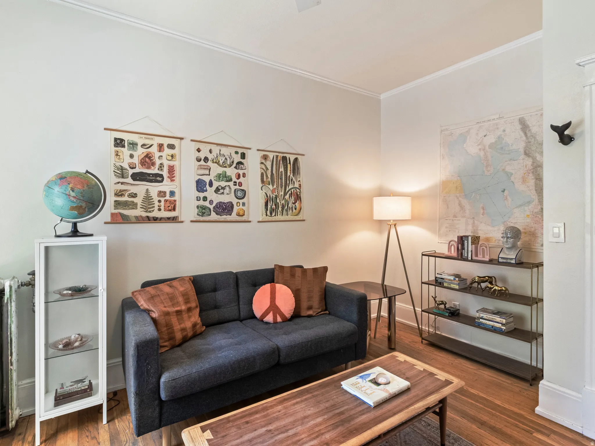 Living space featuring wood-finish flooring, white crown molding, and light-toned wall paint