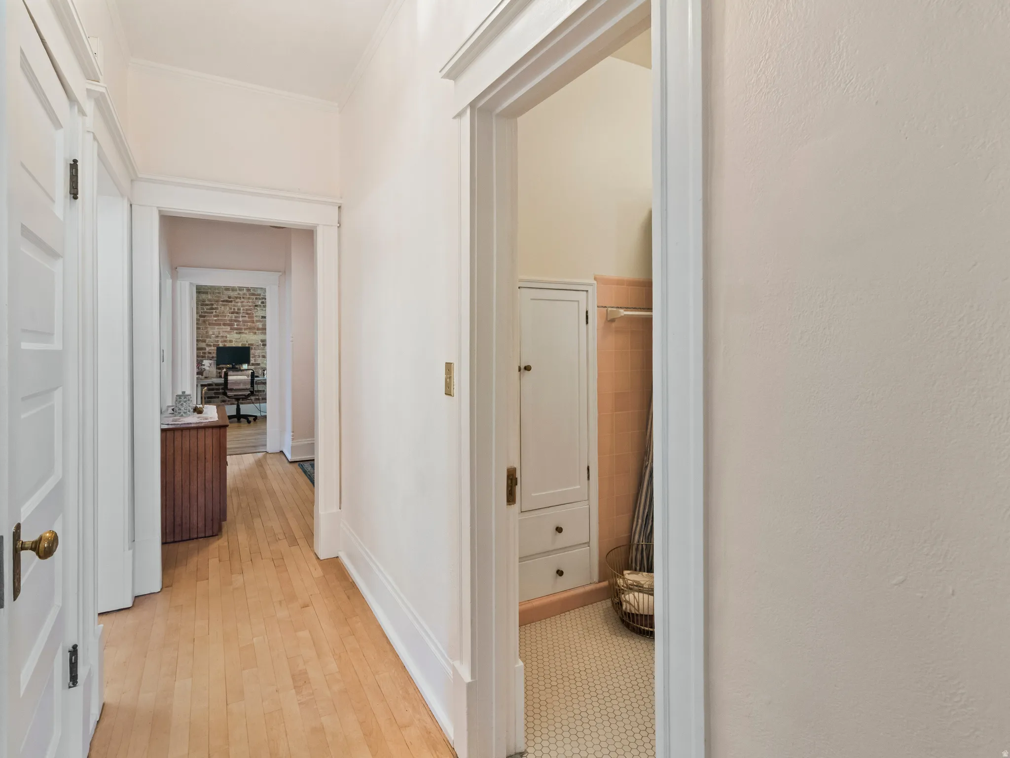 Hallway with wood-finish flooring and white trim