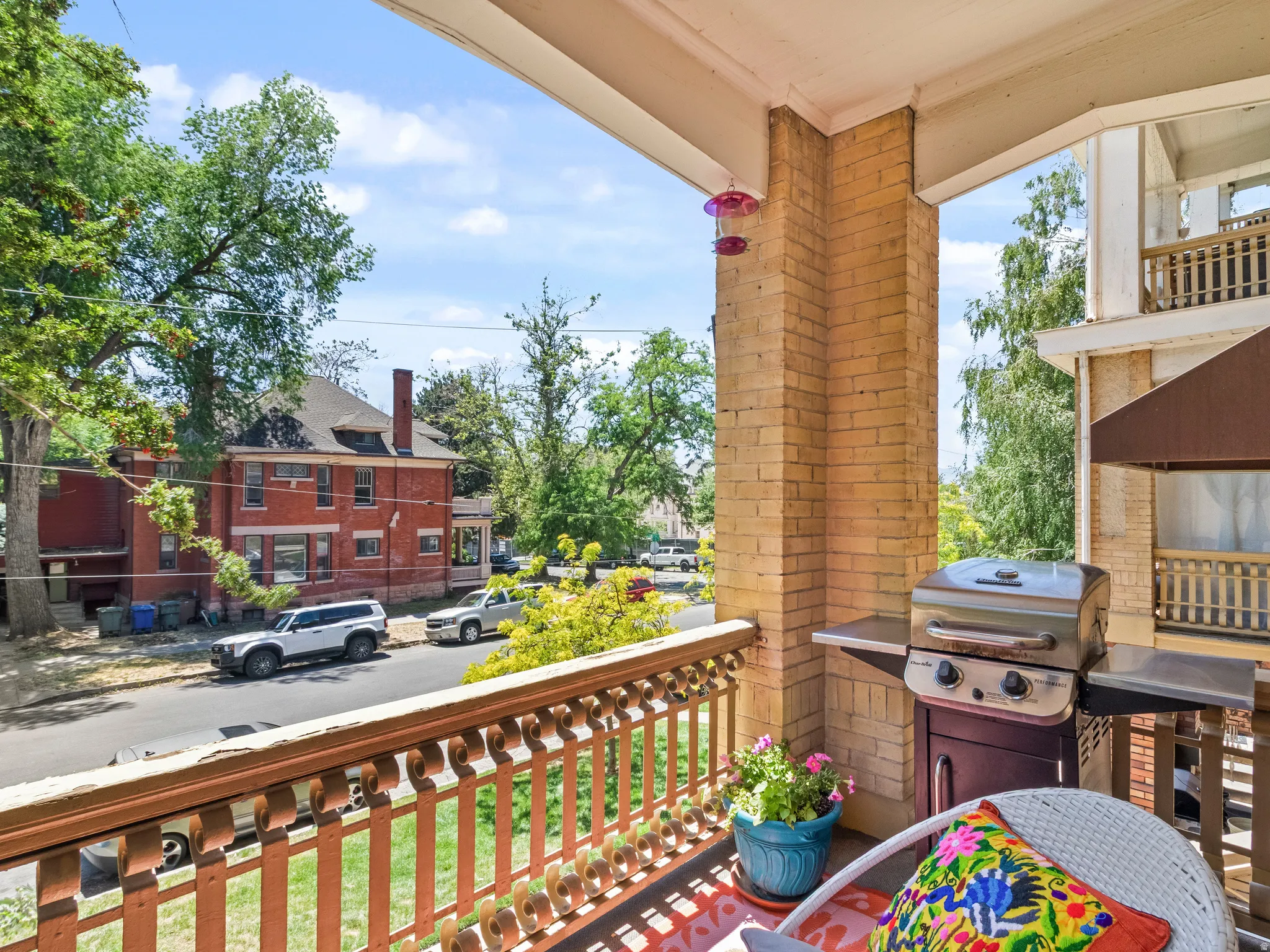 Brick-columned private balcony with a decorative wood railing
