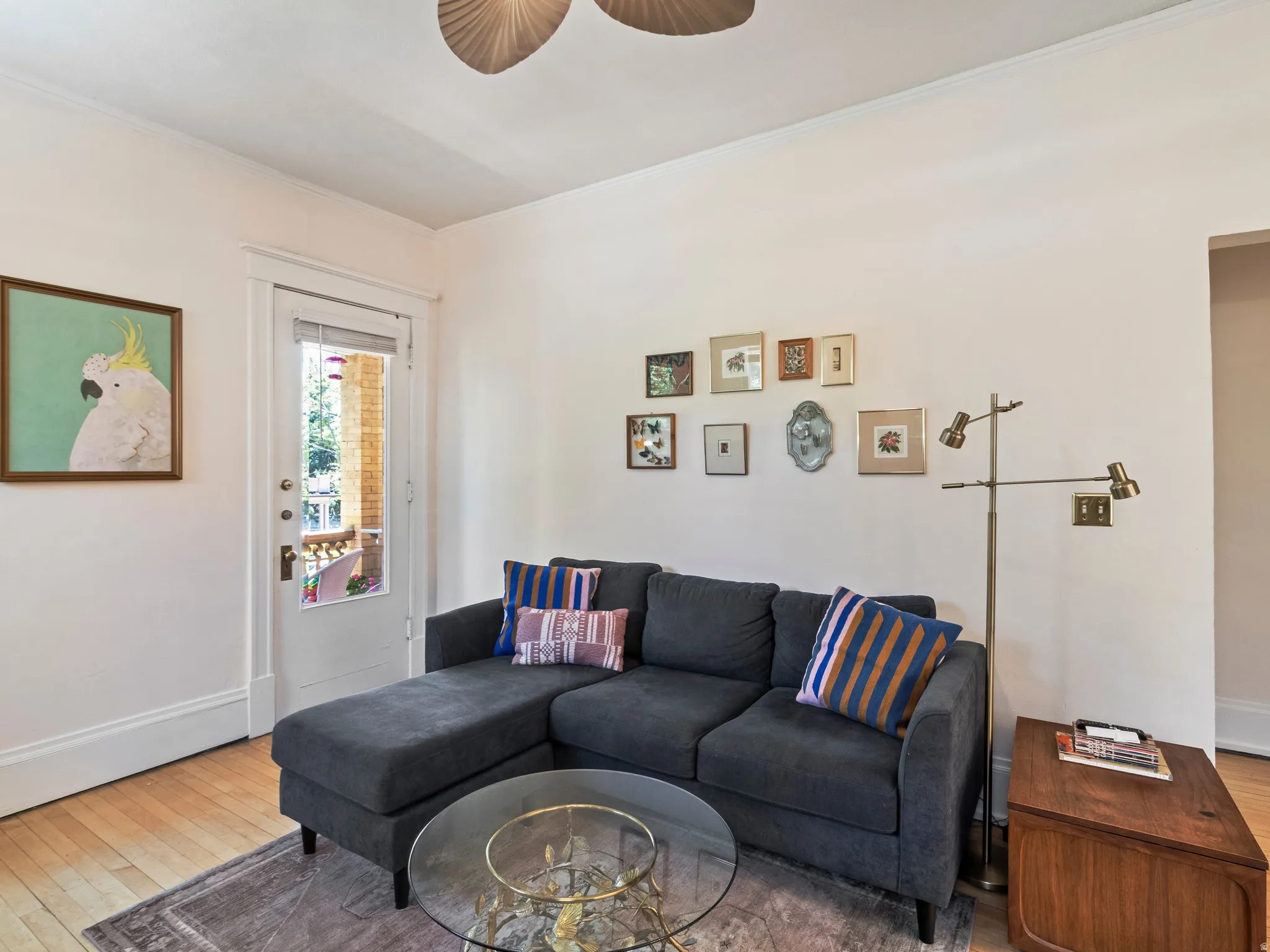 Light wood-finish flooring with white baseboards and crown molding