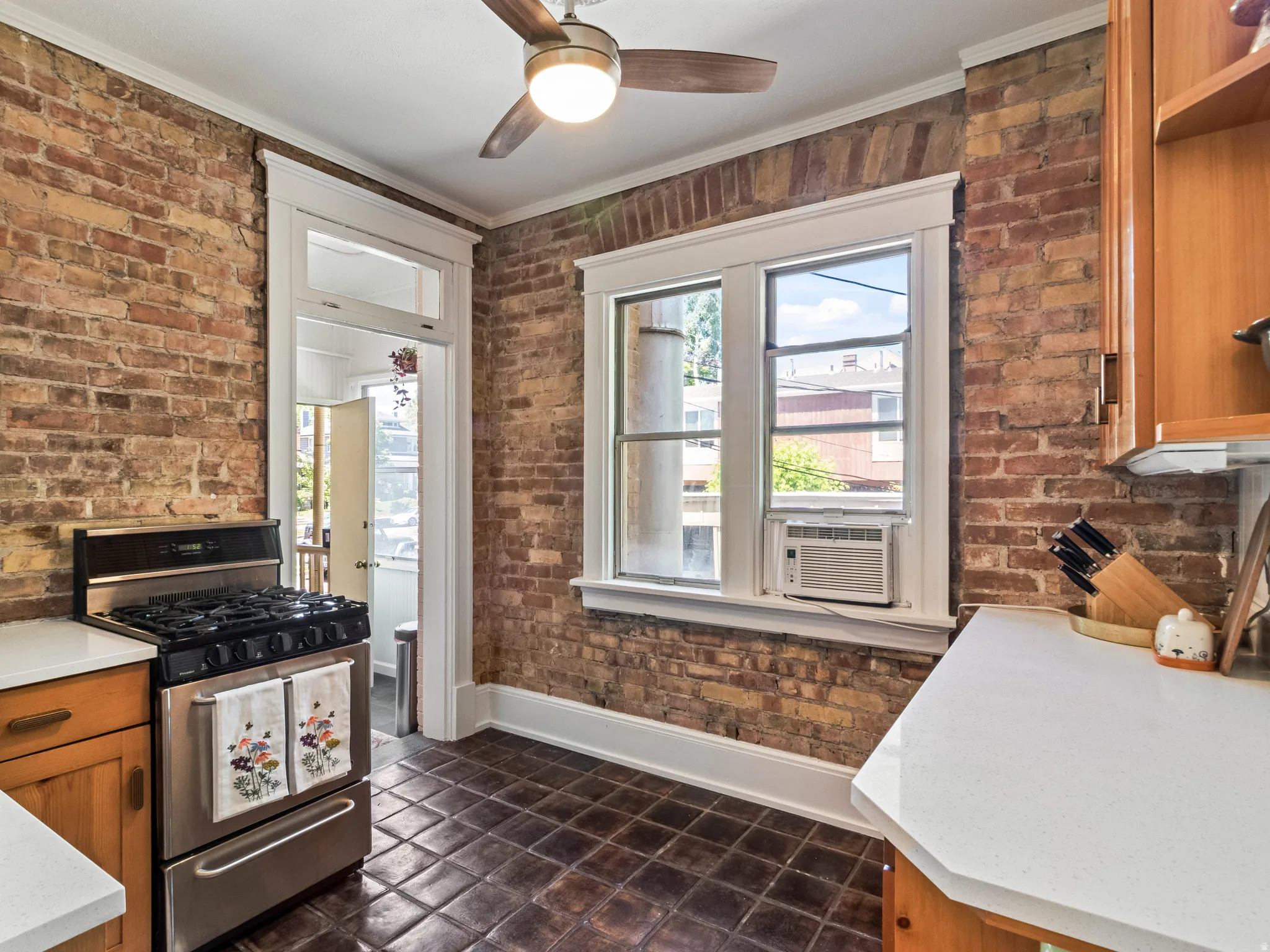 Exposed brick walls defining the space, complemented by a ceiling fan with integrated lighting