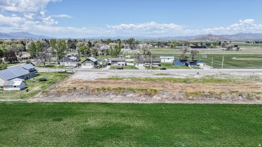 Expansive land parcel featuring a vast green field foreground and a clear view of distant mountains