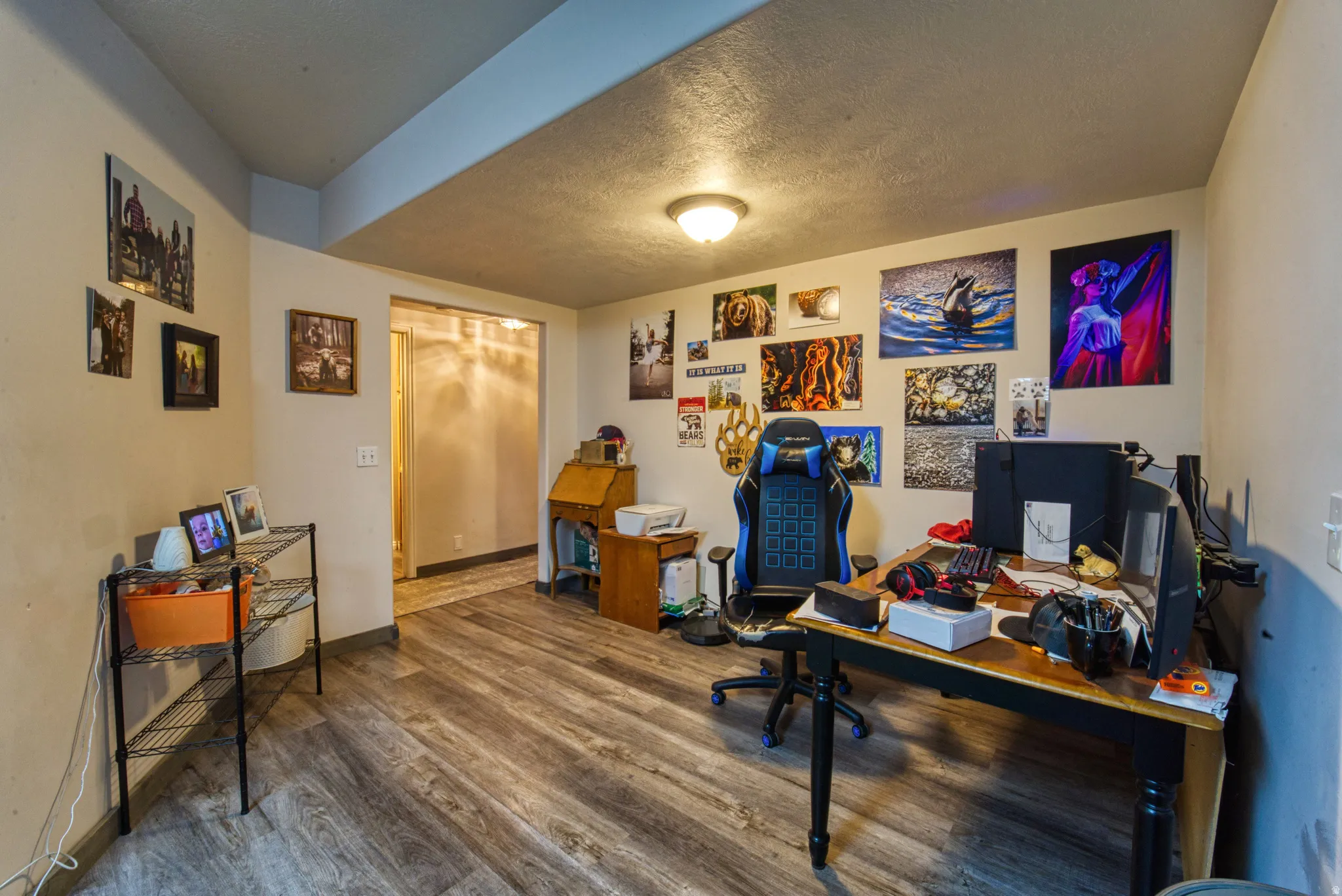 Spacious room featuring wood-finish flooring, a built-in ceiling light fixture, and neutral wall paint