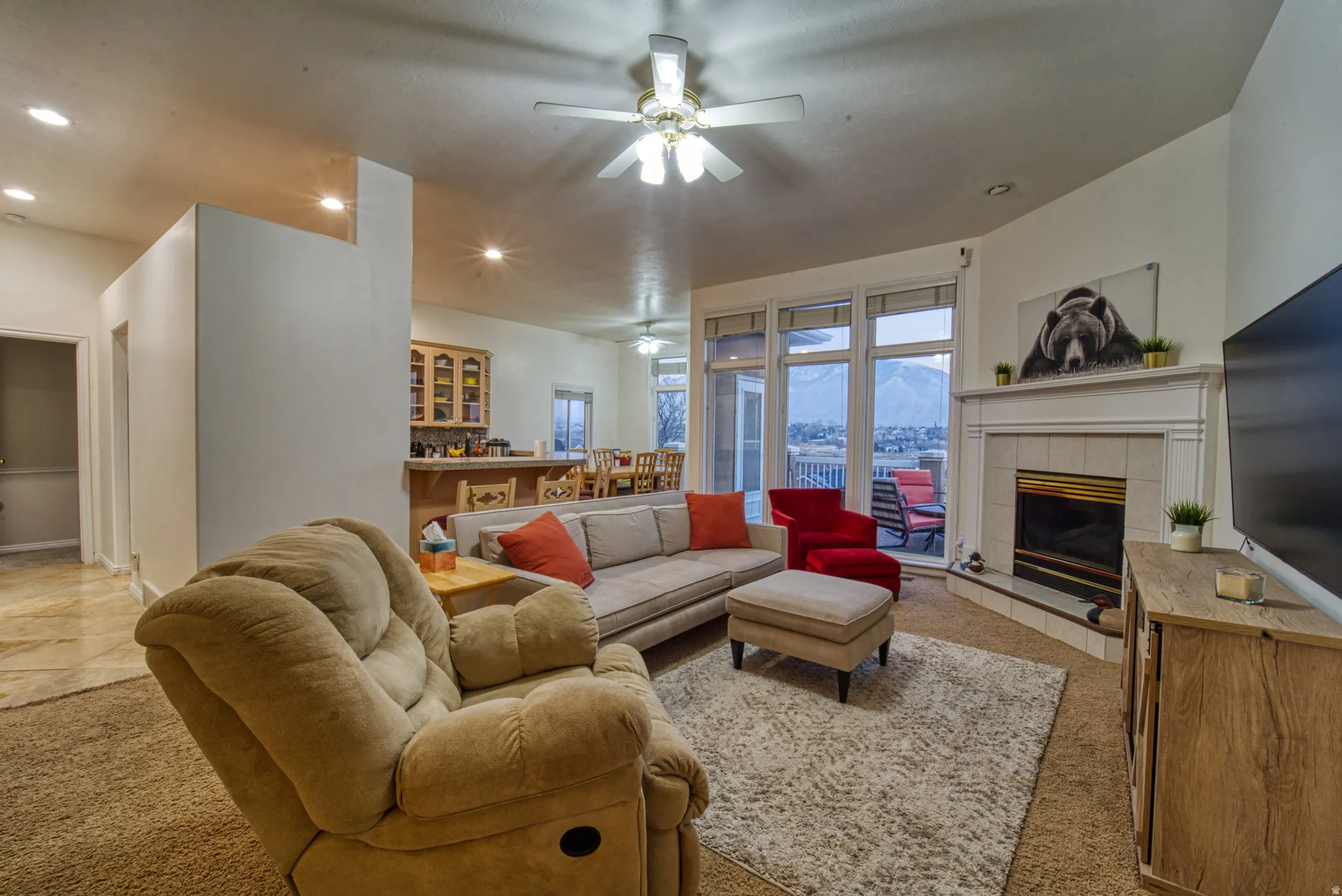 Living area featuring a fireplace with a white mantel, tile surround, and an integrated firebox