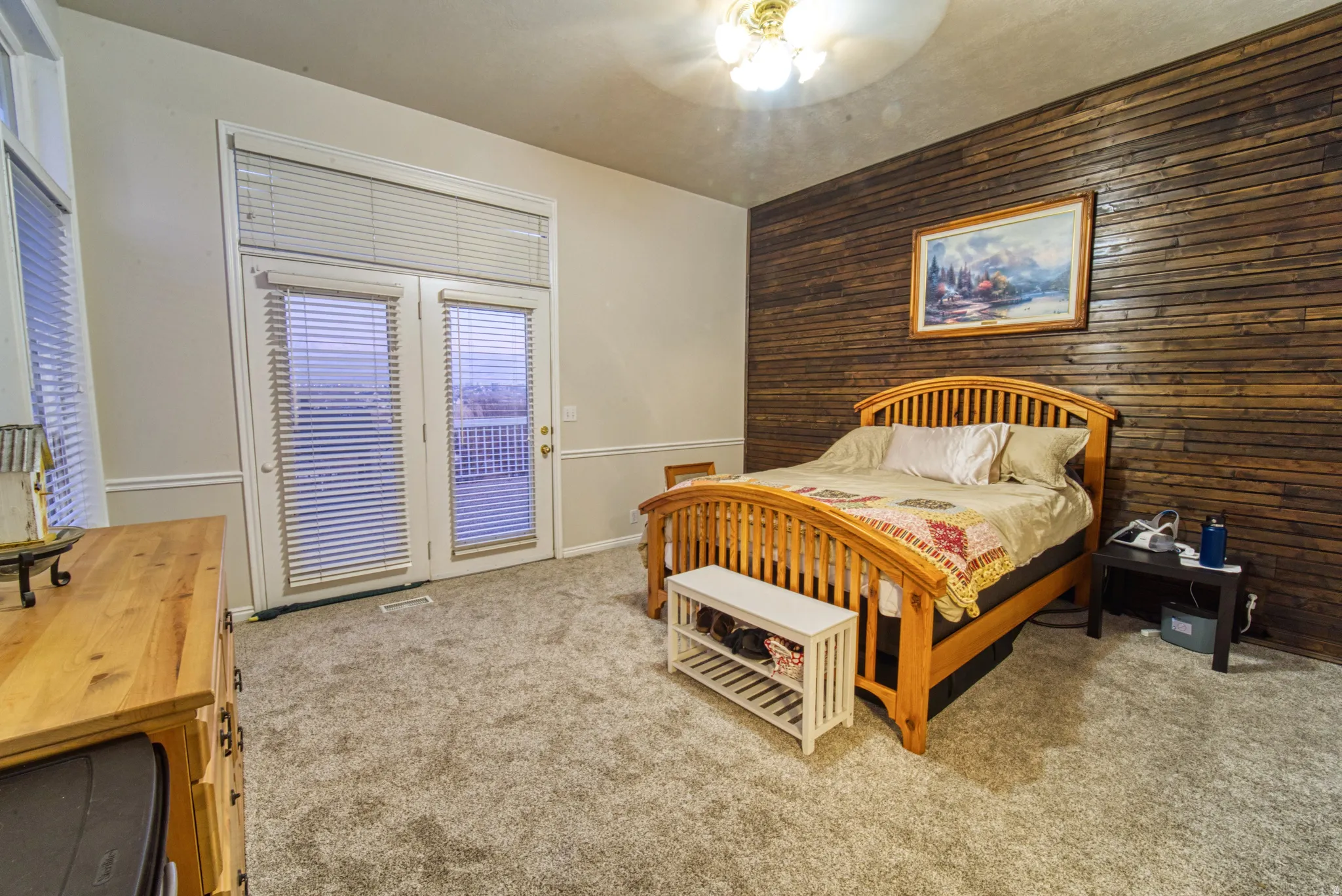 Plush gray carpeting throughout, featuring a textured wood accent wall and white trim
