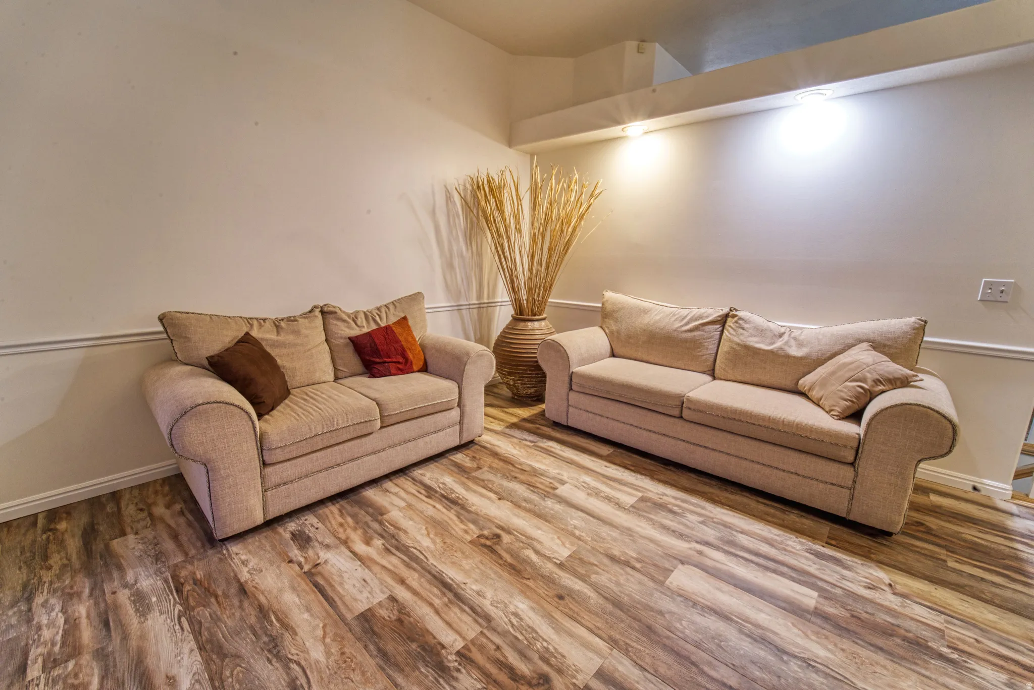 Interior room featuring wood-finish flooring, white walls with chair rail molding, and recessed lighting