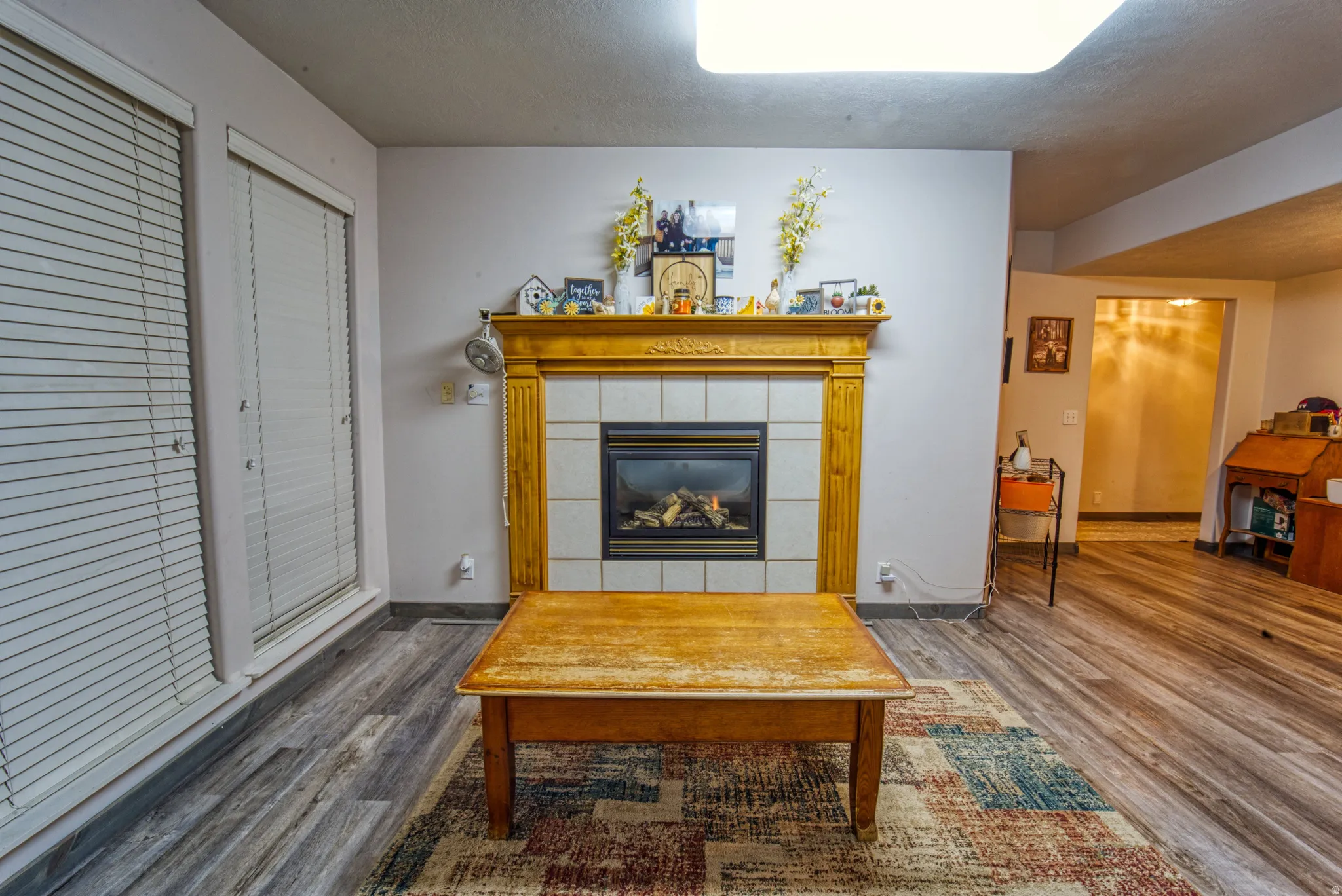Fireplace with a wood mantel and tile surround, set against light-colored walls