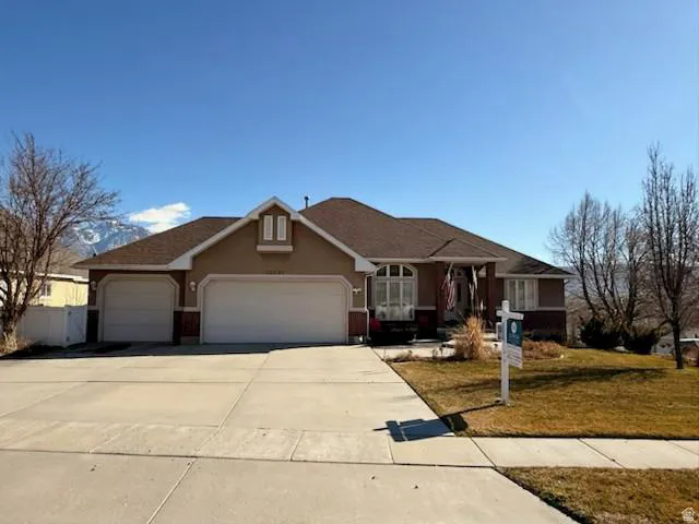 Ranch-style residence featuring a two-car garage, an additional single-car garage, a covered entry, and a prominent bay window