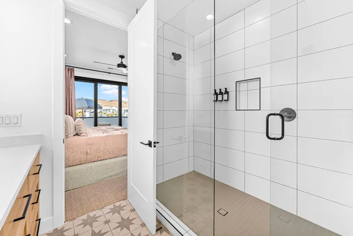 Walk-in shower featuring a glass enclosure, white subway tile surround, and matte black fixtures