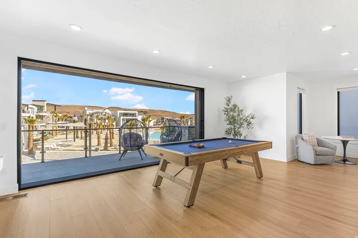 Expansive room featuring a wide sliding glass door, wood-finish flooring, white walls, and recessed lighting