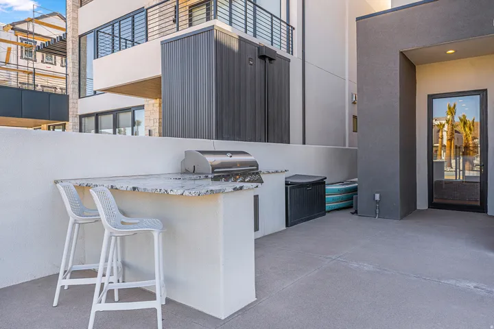 Outdoor patio featuring a built-in barbecue island with a stone countertop and integrated stainless steel grill