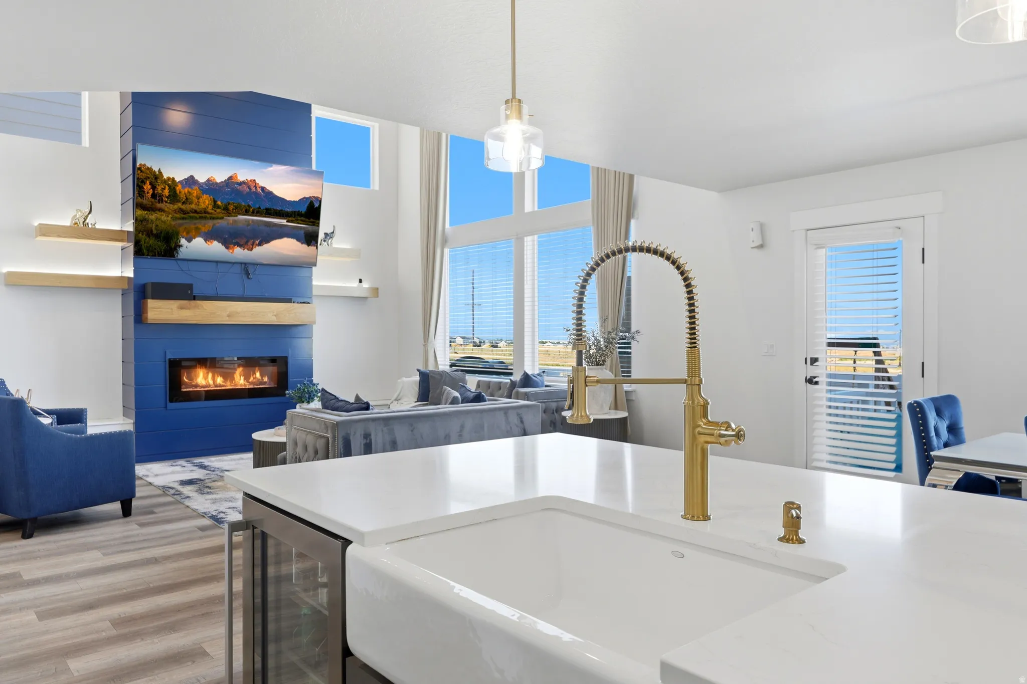 Kitchen island featuring a farmhouse sink and brass-finish faucet, complemented by a built-in beverage cooler