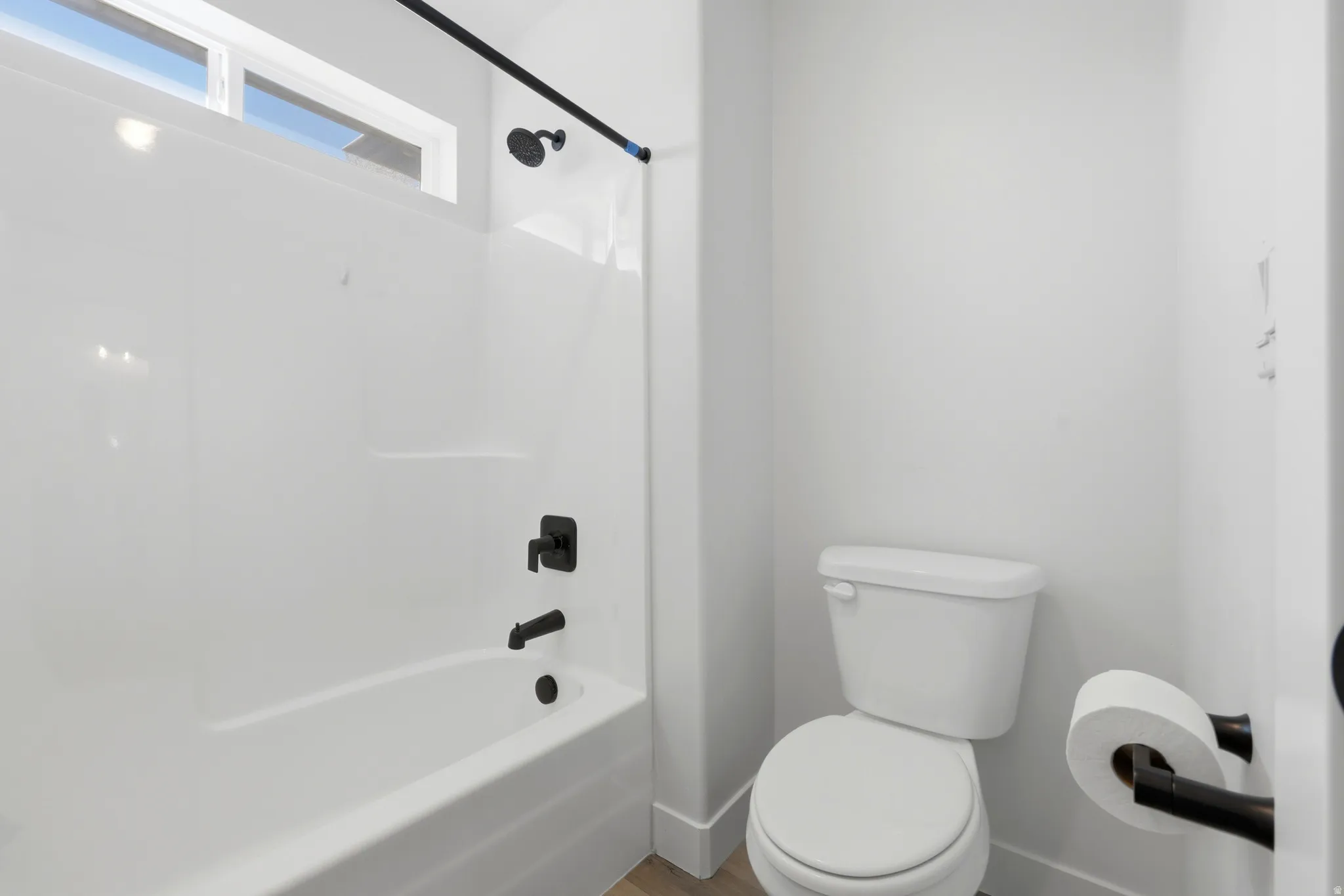 Bathroom featuring a white bathtub and shower combination with matte black fixtures