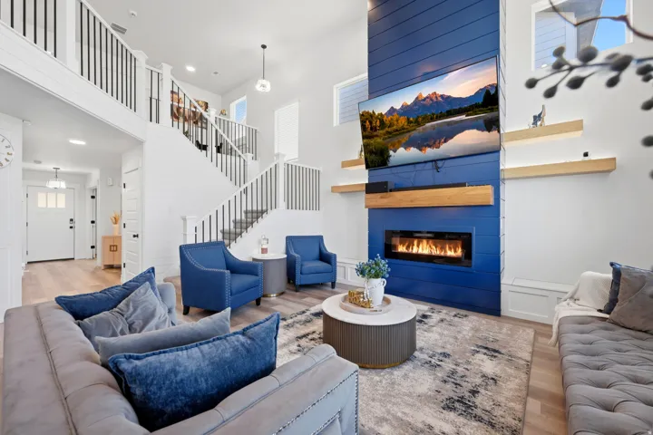 Open-concept living area featuring a prominent blue accent wall with a linear fireplace