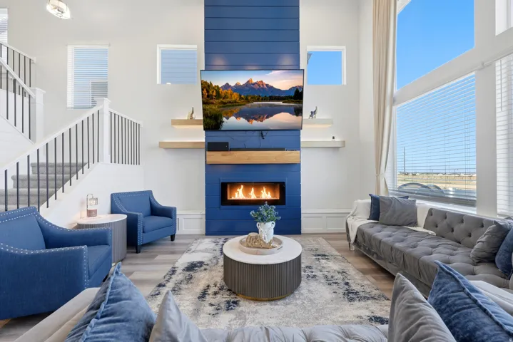 Spacious living area featuring a prominent floor-to-ceiling fireplace with a blue shiplap facade and a built-in linear electric fireplace