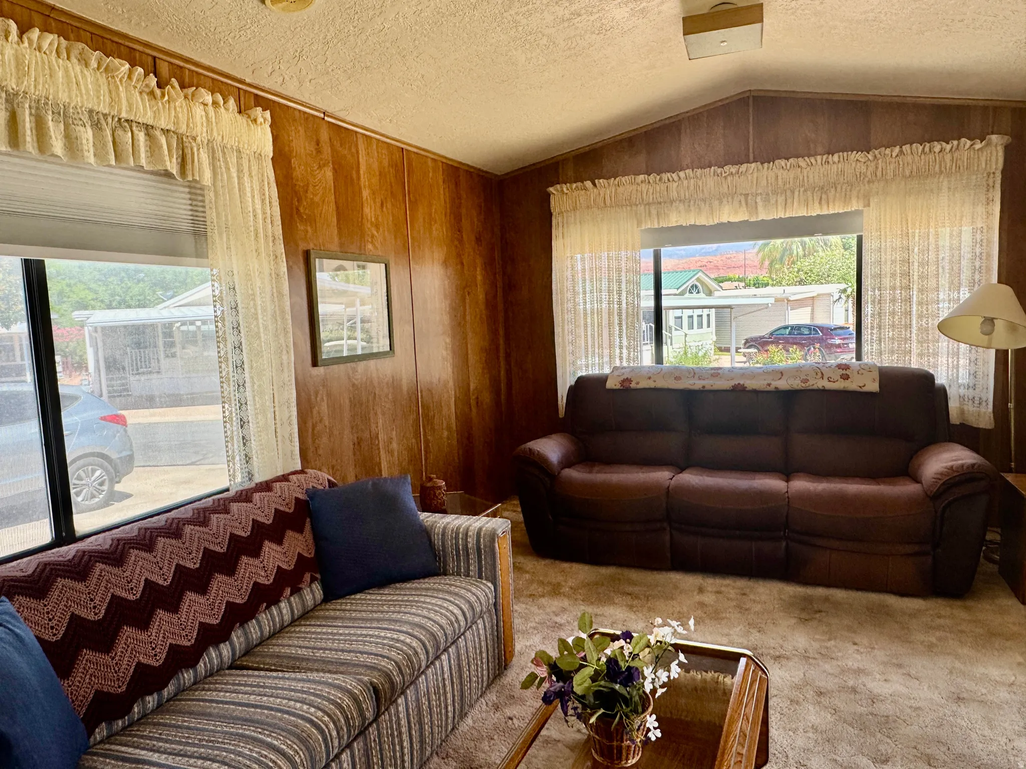 Living area featuring wood-finish wall paneling and a vaulted ceiling